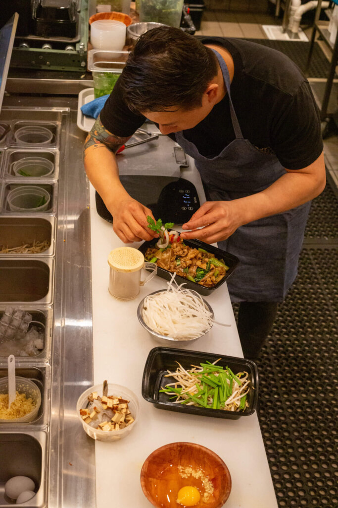 Charles Pokpoonpipat of Baht Thai preparing a dish.